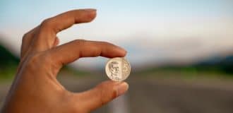 selective focus photography of person holding coin