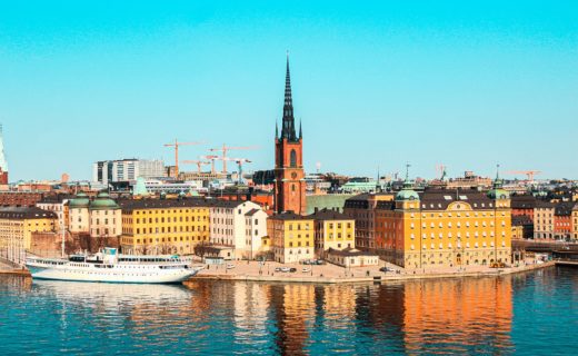white boat on water near city buildings during daytime